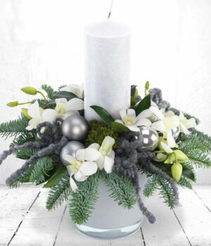 Silver Sheen Candle Arrangement. Candle Arrangement Featuring White Dendrobium Orchids, Green Moss, Blue Spruce, Grey Baubles, And A Central Cream Candle.