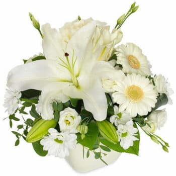 Container White Flowers Featuring A Large White Lily, White Gerbera, And Complementary Blooms Arranged In A Matching White Vase.