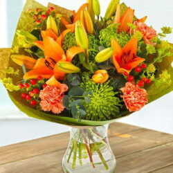 Gold Rush Flower Bouquet Featuring Orange Lilies, Green Chrysanthemums, Orange Carnations, Bupleurum, Red Hypericum Berries, And Eucalyptus Foliage In A Vibrant Design.