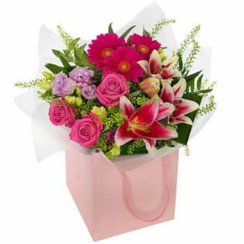 Pleasant Pinks Bouquet Hand-Tied Bouquet Featuring Pink Lilies, Roses, Cerise Germini, Lilac Lisianthus And Seasonal Foliage, Wrapped In Cellophane And Gift Bag.