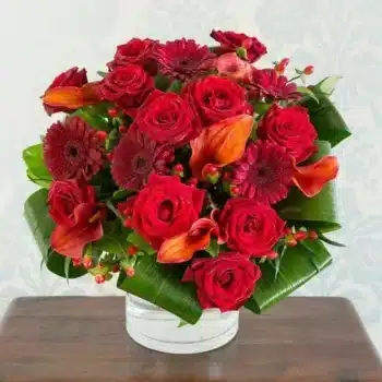 Exquisite Flower Bouquet Featuring Russet Red Roses, Hot Orange Calla Lilies, And Red Hypericum Berries In A Vibrant, Textured Arrangement.