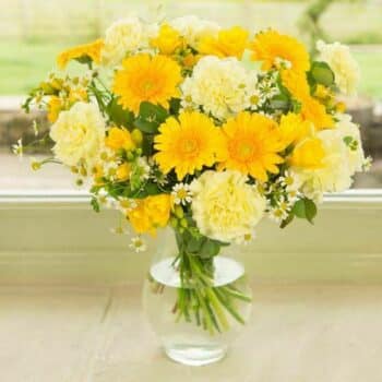 Bright And Cheery Flower Bouquet Featuring Lemon-Yellow Margarite Daisies, Yellow Germini, And Carnations Arranged In A Vibrant, Sunny Design.