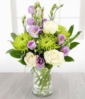 Candlelight Flower Bouquet Featuring Soft Pastel Blooms Arranged Elegantly With Delicate Greenery, Creating A Warm, Romantic Glow.