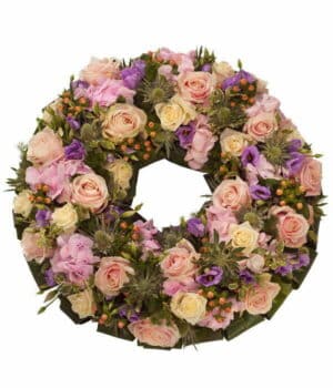 Pastel Wreath Tribute Featuring Pink And Cream Roses, Pink Hydrangea, Hypericum Berries, Purple Lisianthus, White Eryngium, And Lush Foliage.