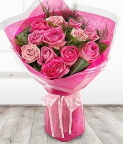 The Chiswick Bouquet Hand-tied bouquet featuring luxurious pink roses in varying shades, arranged in a classic style inspired by Chiswick’s rose garden.