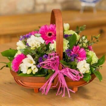 Pretty In Pink Flower Basket Featuring Hot Pink Germini, Carnations, Freesia, Statice, And Eucalyptus Arranged In A Traditional Trug-Style Basket.