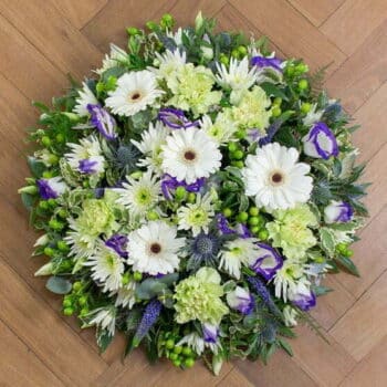 Serene Flower Posy Featuring White Germini, Green Carnations, Hypericum Berries, Purple Veronica, And Blue Eryngium Thistles In A Rustic Design.
