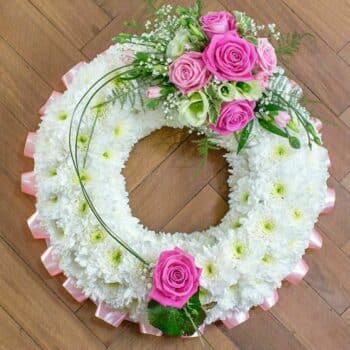 Always And Forever Wreath Featuring A White Chrysanthemum Base, Pleated Ribbon, Roses In Mixed Colours, Spray Carnations, Green Lisianthus, And Foliage.