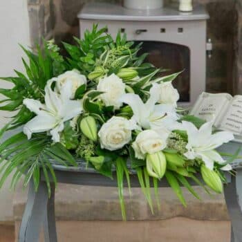 White Satin Spray Arrangement Featuring White Oriental Lilies, Cream Roses, And Fresh Textured Foliage In A Graceful Single-Ended Teardrop Design.
