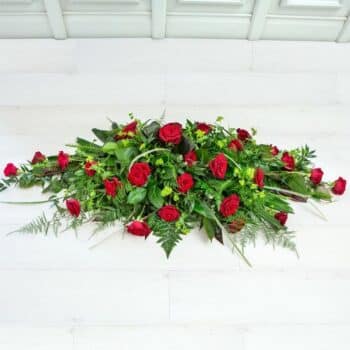 Luxury Rose Spray Arrangement Featuring Fresh Roses In Rich Red, Soft White, Dusky Pink, Or Summer Yellow, Framed With Vibrant Mixed Green Foliage.