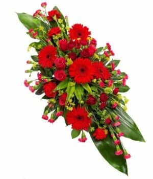 Red Double-Ended Coffin Spray Featuring Roses, Gerbera, Carnations, And Cordyline Foliage Arranged In A Striking Symmetrical Design.
