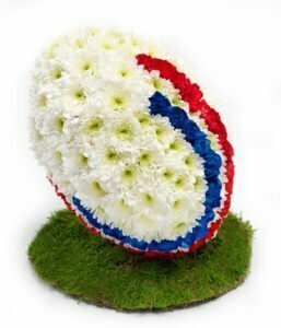 Floral Rugby Ball Tribute Crafted With Fresh Blooms, Designed As A Personalised Funeral Arrangement For A Rugby Enthusiast.