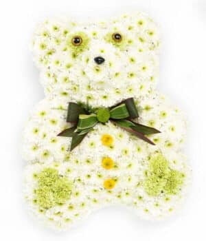 Teddy Bear Flower Tribute Featuring A White Chrysanthemum Base, Green Bow Tie, And Green Chrysanthemum And Carnation Detailing.