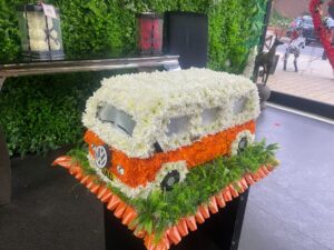 Funeral Flower Tributes VW camper van-shaped funeral tribute made from fresh flowers, featuring vibrant seasonal blooms arranged with precision and creative detailing.