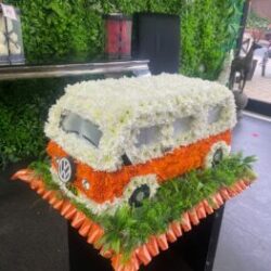 Funeral Flower Tributes VW camper van-shaped funeral tribute made from fresh flowers, featuring vibrant seasonal blooms arranged with precision and creative detailing.