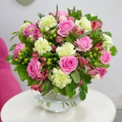 Amelia Flower Bouquet featuring lime-green carnations, pink roses, and crisp green foliage arranged in a hand-tied display