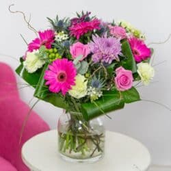 Friendship Flower Bouquet featuring cerise gerberas, baby pink roses, and lime-green carnations arranged in a bright, textured design.